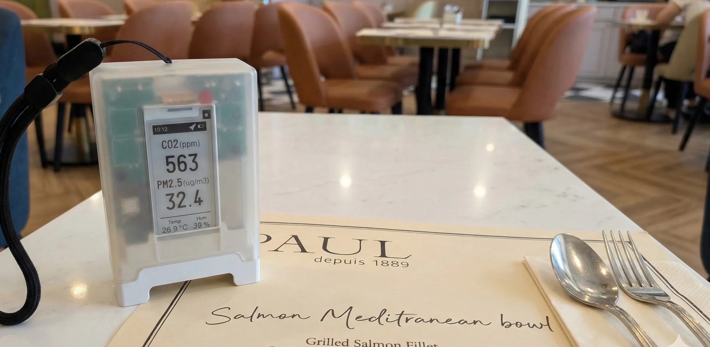 Portable air quality monitor on a table at PAUL cafe
